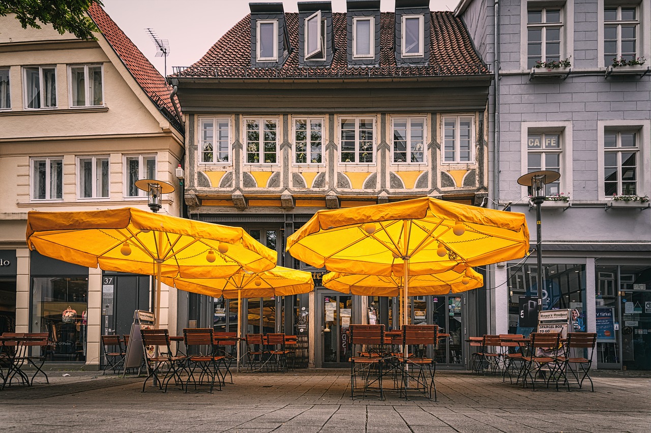 Bâtiment rustique du Pub G6 avec une terrasse et des parasols jaunes